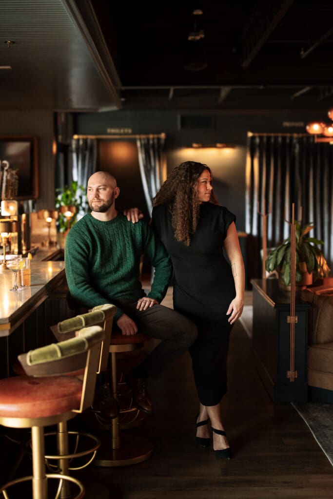 couples standing at a cocktail bar in elegant attire