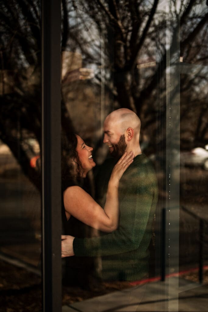 couples holding each other while peering through a window