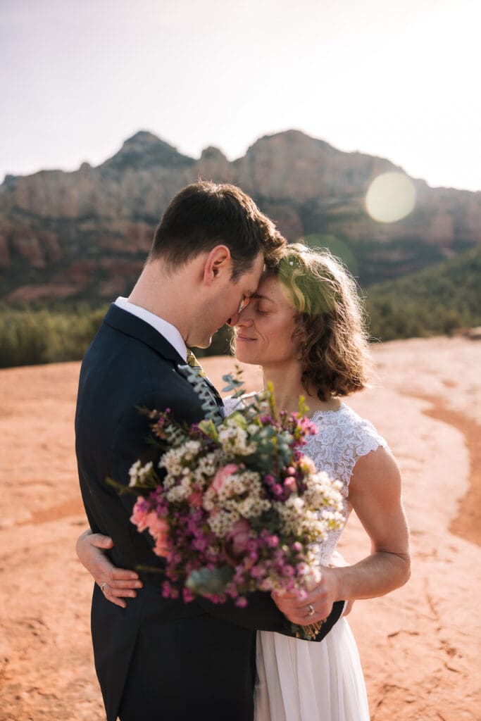 A bride and groom share a moment breathing each other in as husband and wife. 