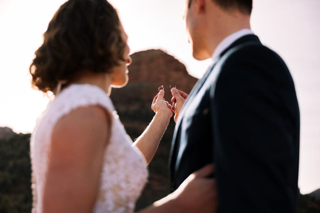 Couple hold their rings up to admire their rings which resembles their bond to each other.