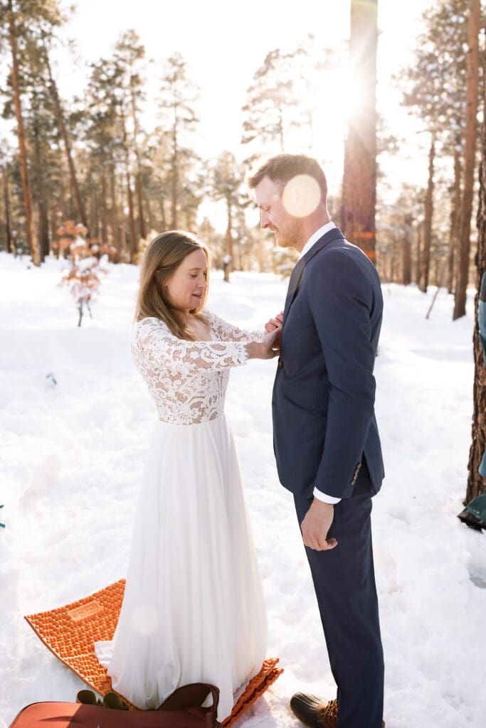 The bride helps tidy up the grooms tie.