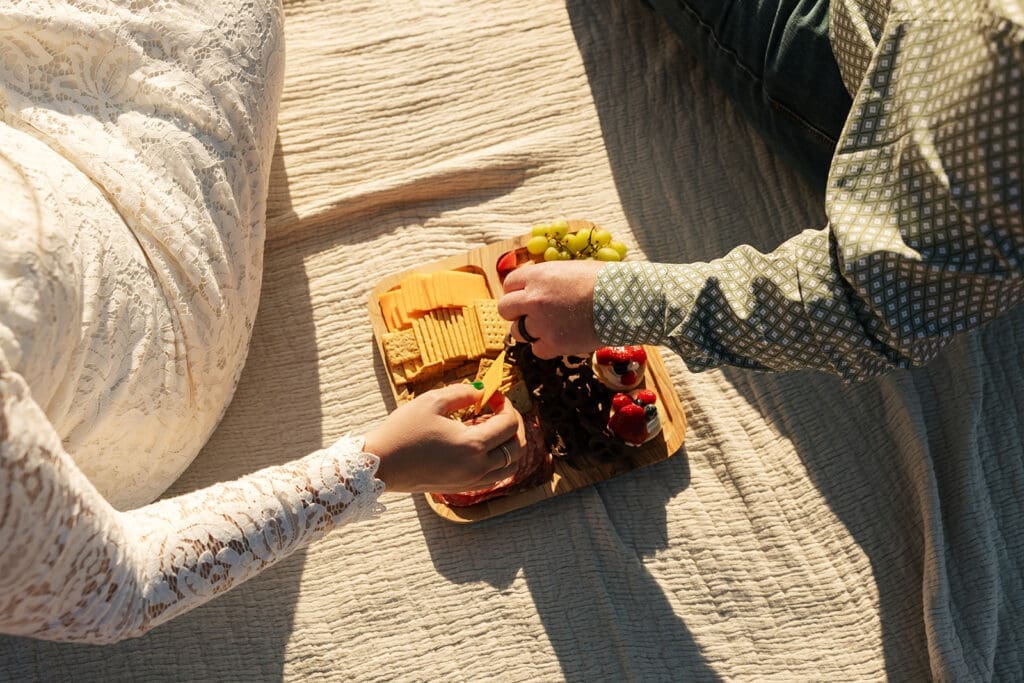 Couple enjoying a picnic with a charcuterie board during their off-roading elopement.
