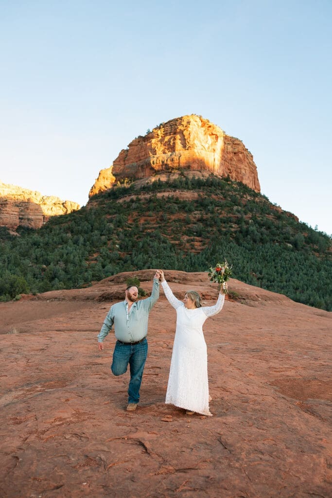 Couple posing on Submarine Rock on an off-road Jeep tour for their Sedona elopement