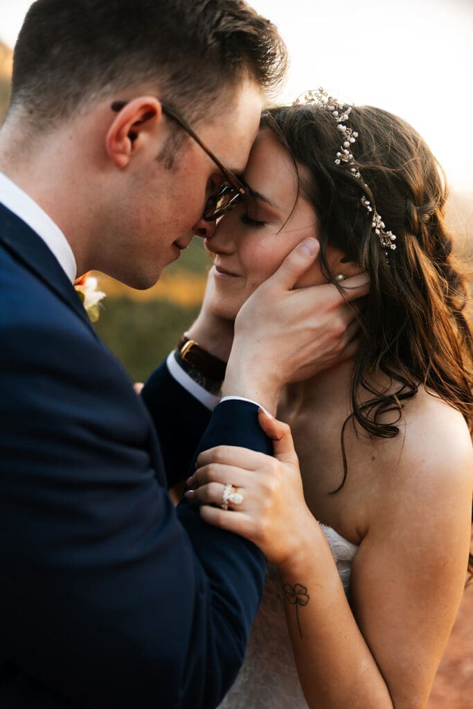 Close-up emotional portrait of a groom tenderly holding his bride’s face during their adventurous Sedona elopement.