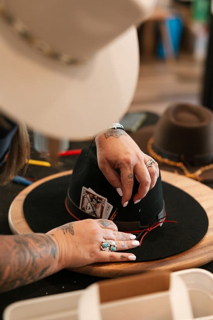 Detailed horizontal shot focusing on the ornate leatherwork and intricate design on the crown of a black customized elopement hat.