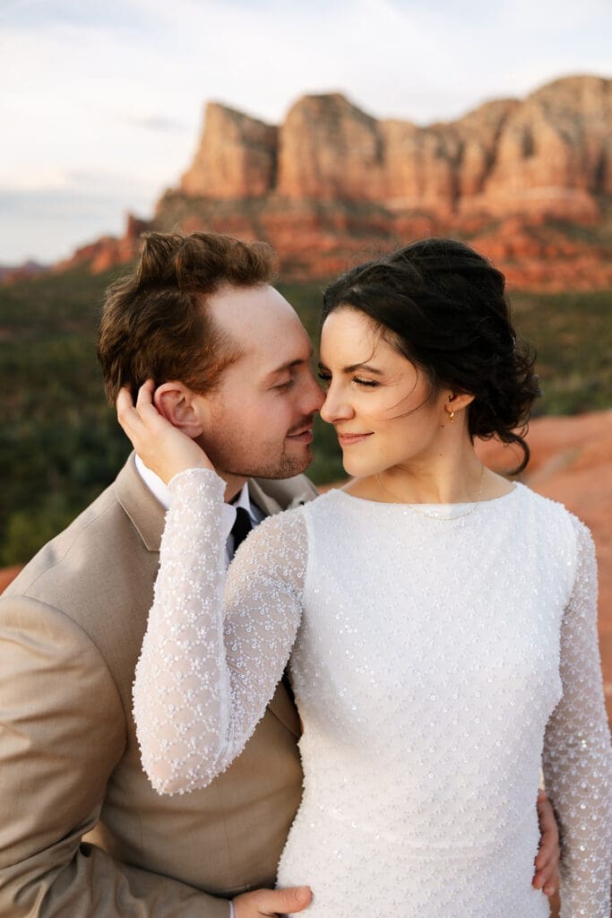 Intimate close-up portrait of the newlyweds holding each other closely and sharing a tender look during golden hour in Sedona.