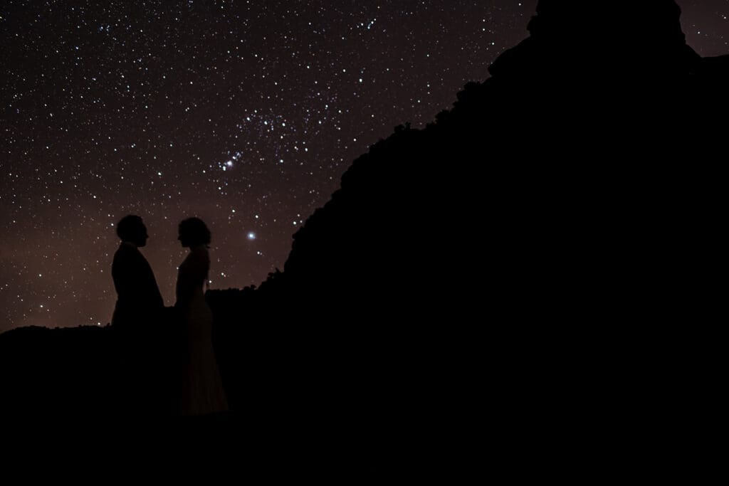 Silhouette of an elopement couple posing under a starry night sky during a spring Sedona elopement.