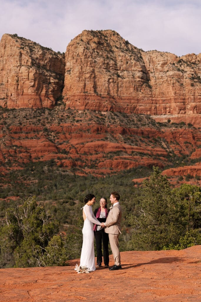 Wide landscape shot of the towering red rock formations at Baby Bell Rock in Sedona under a clear blue sky.