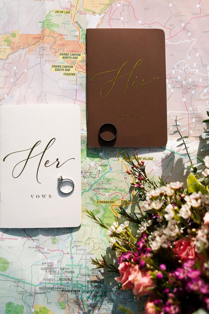 An elopement flat lay that includes a trail map with rings and vow books.