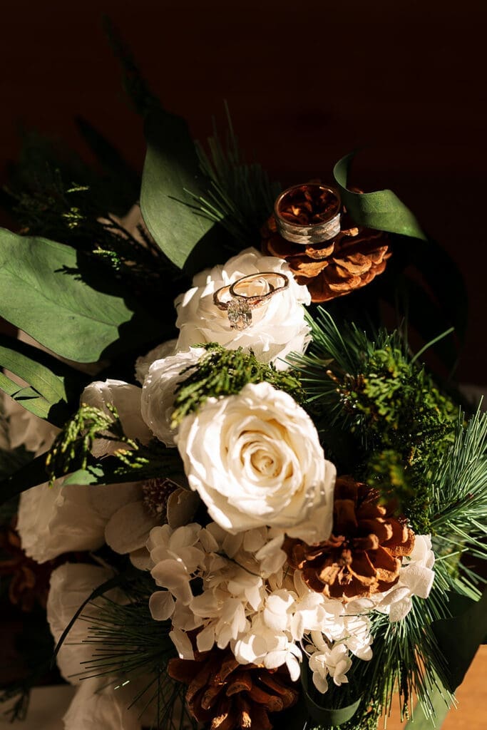A ring set is placed on florals as the sun shines through the window.